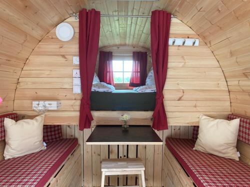 um pequeno quarto com duas camas numa pequena casa em Schlaffässer auf dem Krügele Hof em Murr