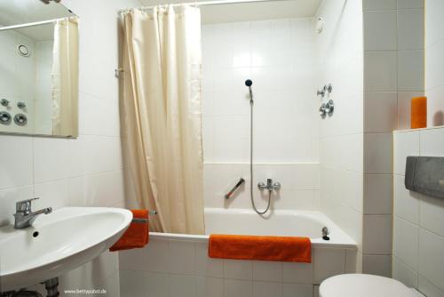 ein Badezimmer mit einem Waschbecken, einer Badewanne und einem WC in der Unterkunft Apartment an der Uni mit Tiefgarage und Loggia in Leipzig