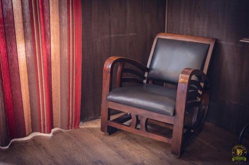 uma cadeira de madeira sentada num canto de um quarto em The Liberty's em Villefranche-sur-Saône