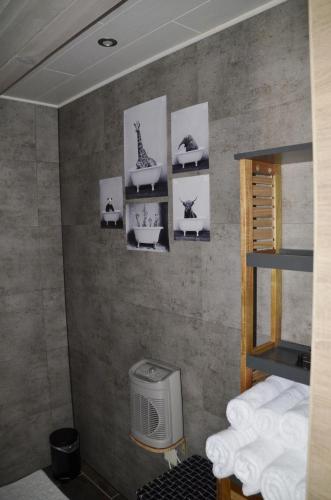 a bathroom with a wall with pictures on it at Gîtes Paille-Foin in Cerfontaine