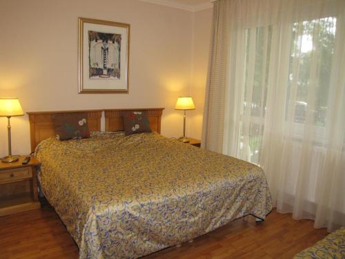 a bedroom with a bed and a window at Pávai Vendégház in Hajdúszoboszló