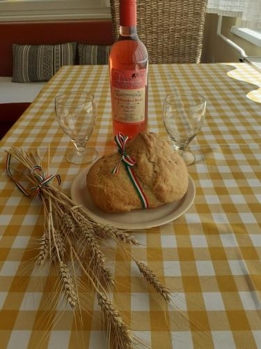 a bottle of wine and a loaf of bread on a table at Kurca-parti Vendégház in Szentes