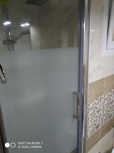 y baño con ducha y puerta de cristal. en Studio Stesi Peraia Thessaloniki s, en Perea
