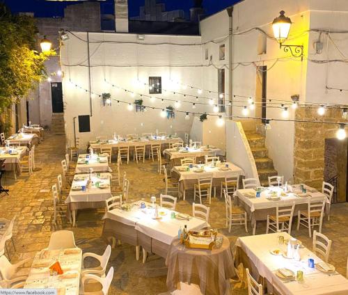 a restaurant with white tables and chairs and lights at B&B Suite "Caniglia" in Mesagne