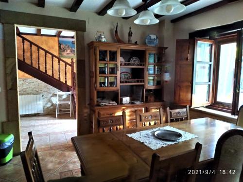 a dining room with a wooden table and chairs at La Chimenea Cantabra in Oreña