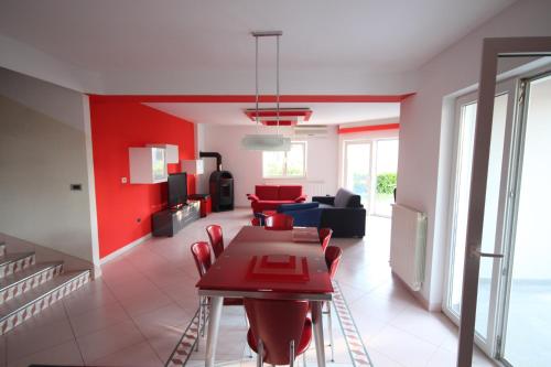 a living room with a table and red chairs at Holiday house Veli vrh in Pula