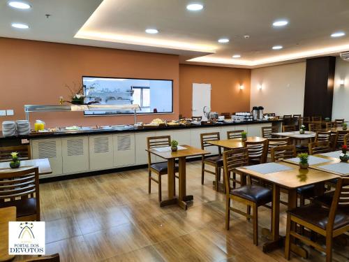 a restaurant with tables and chairs and a counter at Hotel Portal dos Devotos in Aparecida