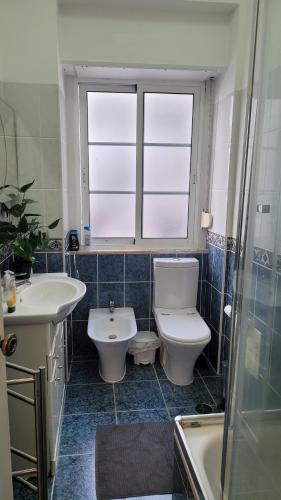 a bathroom with a toilet and a sink and a tub at Room I - Atalaia - Bairro Alto in Lisbon