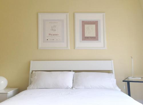 a bedroom with two framed pictures above a bed at Room I - Atalaia - Bairro Alto in Lisbon
