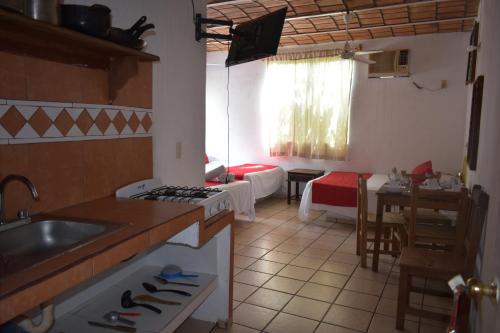 a kitchen with a sink and a stove top oven at Hotel Y Bungalows Islas Careyes in Los Ayala