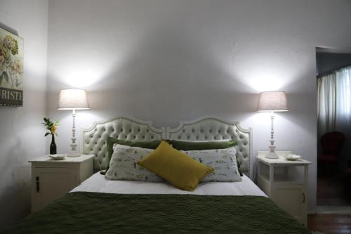 ein Schlafzimmer mit einem Bett mit zwei Nachttischen und zwei Lampen in der Unterkunft Doornfontein Guest Farm in Cradock
