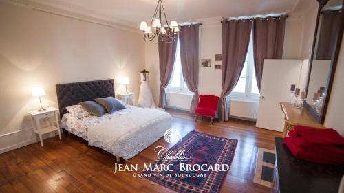 sypialnia z łóżkiem i czerwonym krzesłem w obiekcie Maison des 7 lieux w mieście Chablis