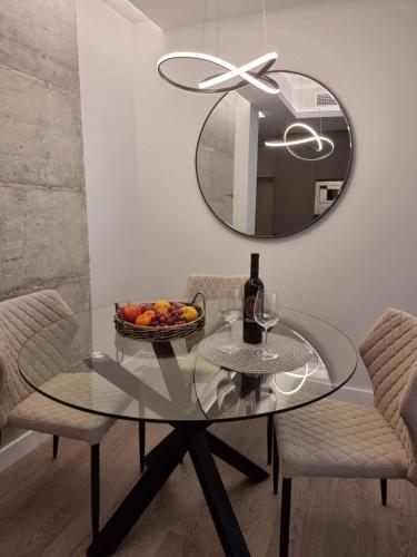 un tavolo di vetro con un cesto di frutta e uno specchio di Malaga a Tu Ritmo! Edificio muy tranquilo y moderno! a Málaga