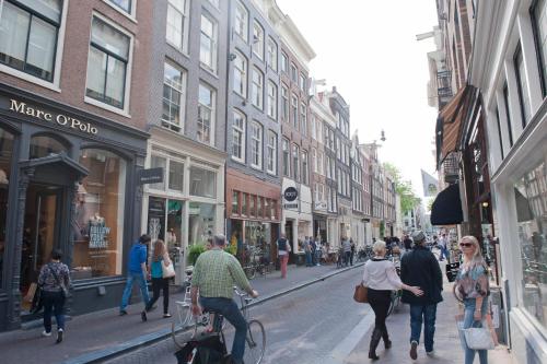 a group of people walking down a busy city street at Hotel IX Nine Streets Amsterdam in Amsterdam