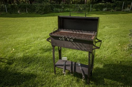 a barbecue grill sitting in the grass in a yard at Lauku iela 25 in Jūrmala
