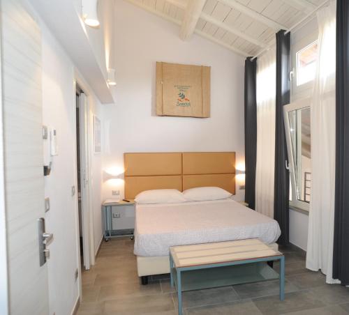 a small bedroom with a bed and a table at TLcafè Hospitality (presso Torrefazione Lady Cafè srl) in San Secondo Parmense