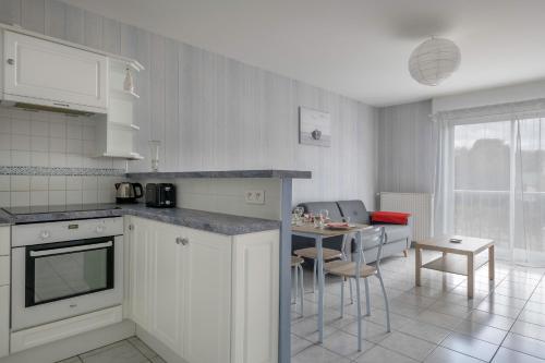 une cuisine avec un comptoir et une table avec des chaises dans l'établissement La Baule, 300m de la plage - Appart pour 4, à Pornichet