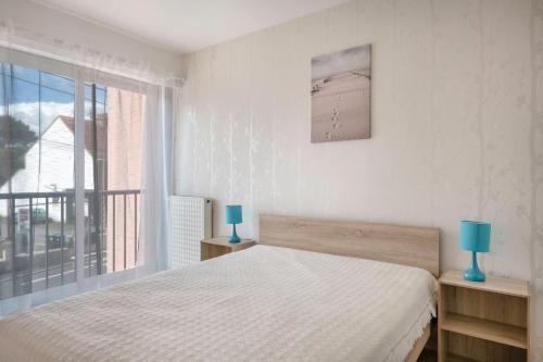 une chambre avec un lit et une grande fenêtre dans l'établissement La Baule, 300m de la plage - Appart pour 4, à Pornichet