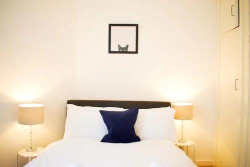 愛丁堡的住宿－GuestReady - Calm and Central sleeps up to 6，一间卧室配有一张带蓝色枕头的床和两盏灯。