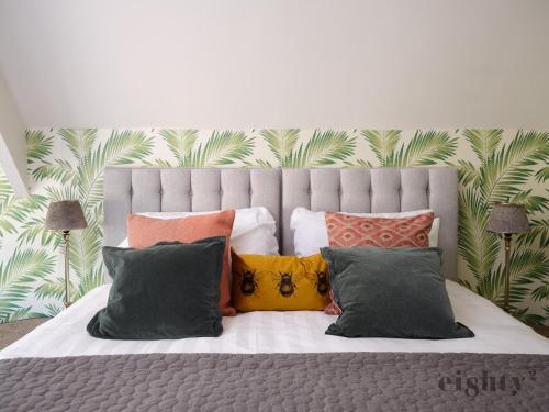 a bed with a bunch of pillows on it at The Prince of Waterloo - Boutique Guest Rooms in Winford