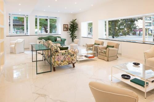 a living room with couches and tables and windows at Hotel Morfeo in Milan