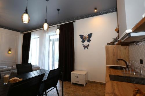a living room with a table and a butterfly on the wall at Villa Bonapart in Zatoka