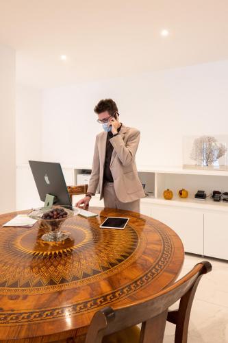 a man talking on a phone at a table with a laptop at Hotel Morfeo in Milan