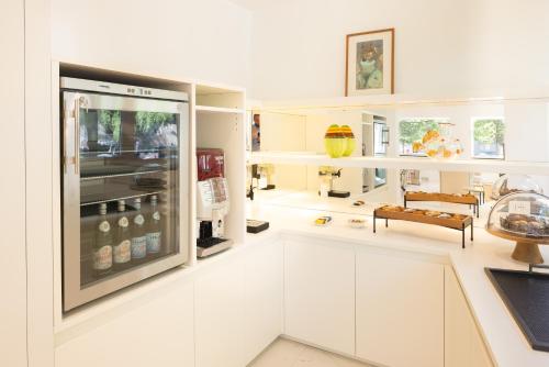 a kitchen with white cabinets and a large window at Hotel Morfeo in Milan