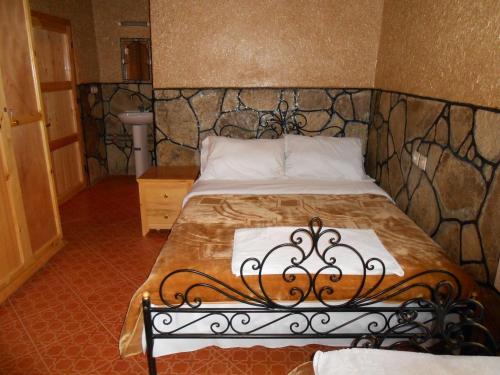 a bedroom with a bed with a wrought iron headboard at La Petite Gorge, Hôtel & Restaurant Todra Gorge in Tinerhir