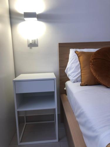 a bed with a white nightstand next to a bed with at NANNARE' APPARTAMENT in Reggio Emilia