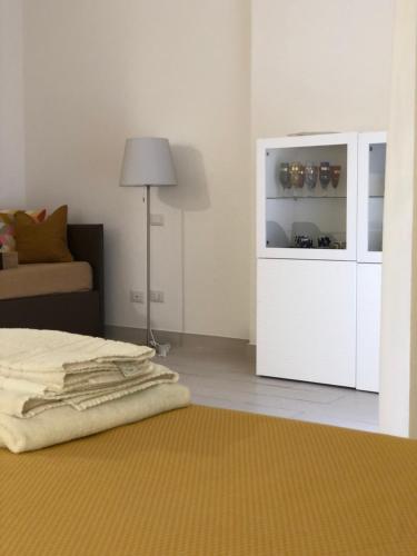 a bedroom with a bed and a white cabinet and a lamp at NANNARE' APPARTAMENT in Reggio Emilia