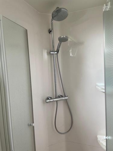 La salle de bains est pourvue d'une douche et d'un miroir. dans l'établissement Terrasses de Malmedy Chalet l'undeuxtrois, à Malmedy