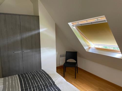 a bedroom with a bed and a window and a chair at Terrasses de Malmedy Chalet l'undeuxtrois in Malmedy