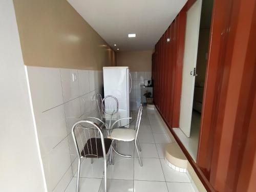 a kitchen with chairs and a table and a refrigerator at Container LB com garagem para carros de até 4,5M in Boa Vista