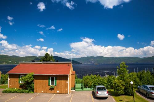 a building with a car parked in a parking lot at Chalets Condos sur le Fjord in LʼAnse-Saint-Jean