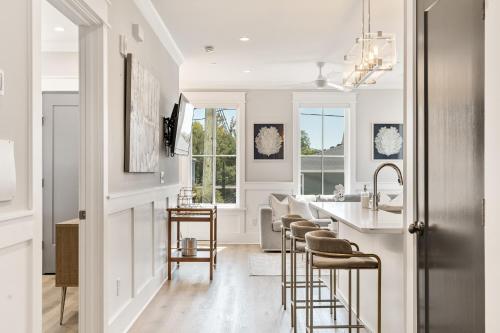 a kitchen with bar stools and a kitchen with white walls at The Jasmine Suite at 124 Spring in Charleston