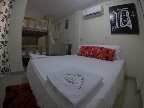 a bedroom with a white bed with red pillows at La casita de max y tim apt 201 in Cartagena de Indias