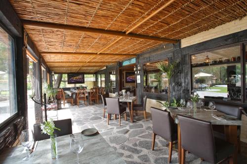 un comedor con mesas, sillas y ventanas en Real de Corralejo, en San Miguel de Allende