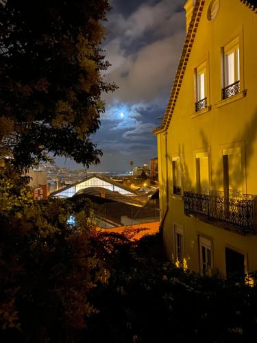 a view of a building and a bridge at night at Safestay Lisbon Bairro Alto in Lisbon