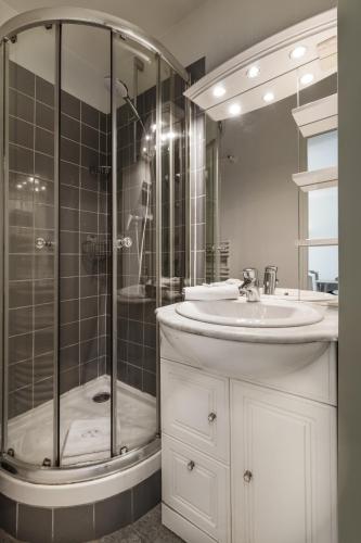 une salle de bain blanche avec une douche et un lavabo dans l'établissement Central & functional apartment at Châtelet, à Paris