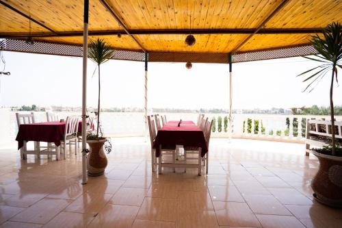 a restaurant with tables and chairs and a view of the water at El Mesala Hotel in Luxor