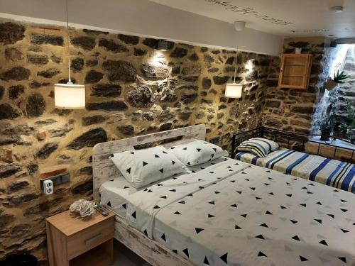 a bedroom with a stone wall with a bed at CITY CENTER VILLA in Kavála
