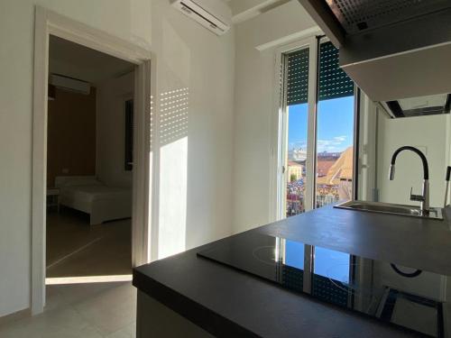 a kitchen with a black counter top and a window at DaRò Apartments in Bologna