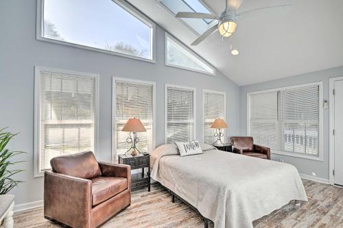 a bedroom with a bed and two chairs and windows at Murrells Inlet Studio Less Than 2 Mi to Marsh Walk in Myrtle Beach