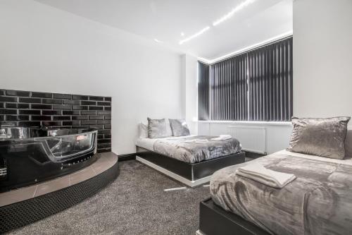 um quarto com uma lareira, uma cama e um sofá em Mixies Manor Sasco Apartments em Blackpool