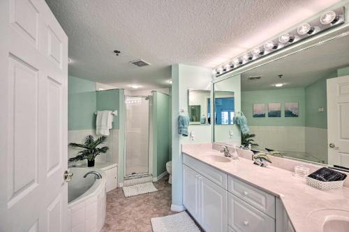 La salle de bains est pourvue de 2 lavabos, d'une douche et d'un miroir. dans l'établissement Poolside Sun and Fun Condo Near New Smyrna Beach!, à New Smyrna Beach