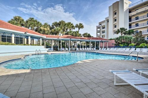 a swimming pool with chairs and a building at Walk to Ocean Condo with Pool in New Smyrna Beach in New Smyrna Beach
