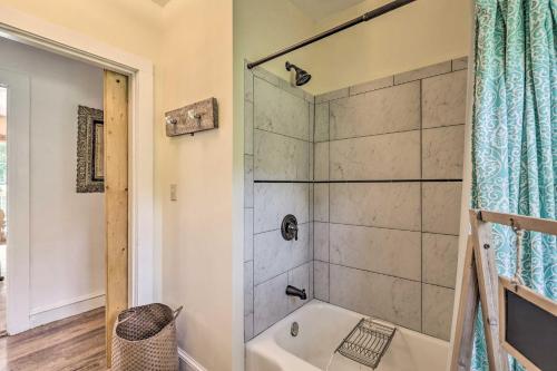La salle de bains est pourvue d'une douche et d'une baignoire blanche. dans l'établissement Cozy Blue Ridge Cottage - Bike, Hike, and Fish!, à Bakersville