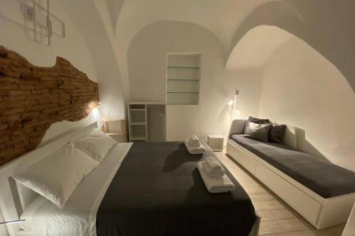 sypialnia z łóżkiem i kanapą w obiekcie Catania Dammuso house w Katanii
