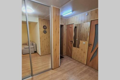a room with wooden walls and glass doors at Butas Ignalinos centre poilsiui ir darbostogoms in Ignalina